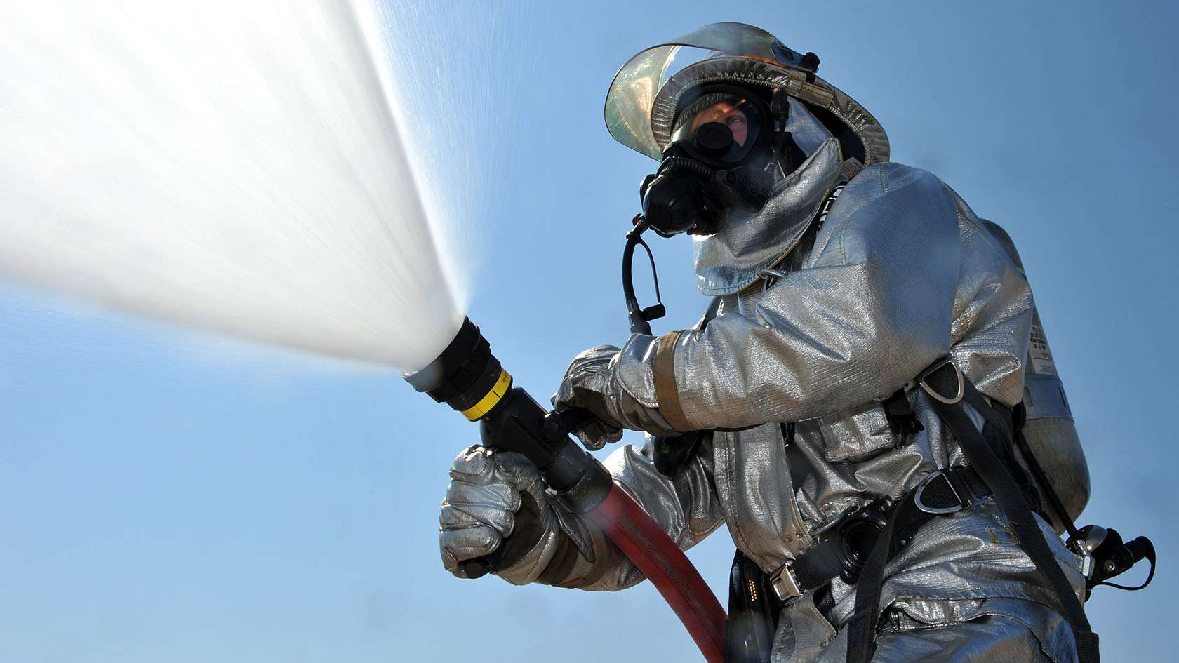 fireman spraying water from firehose